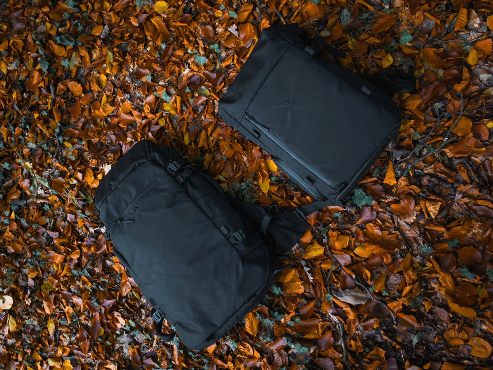 Two black bags on a bed of autumn leaves